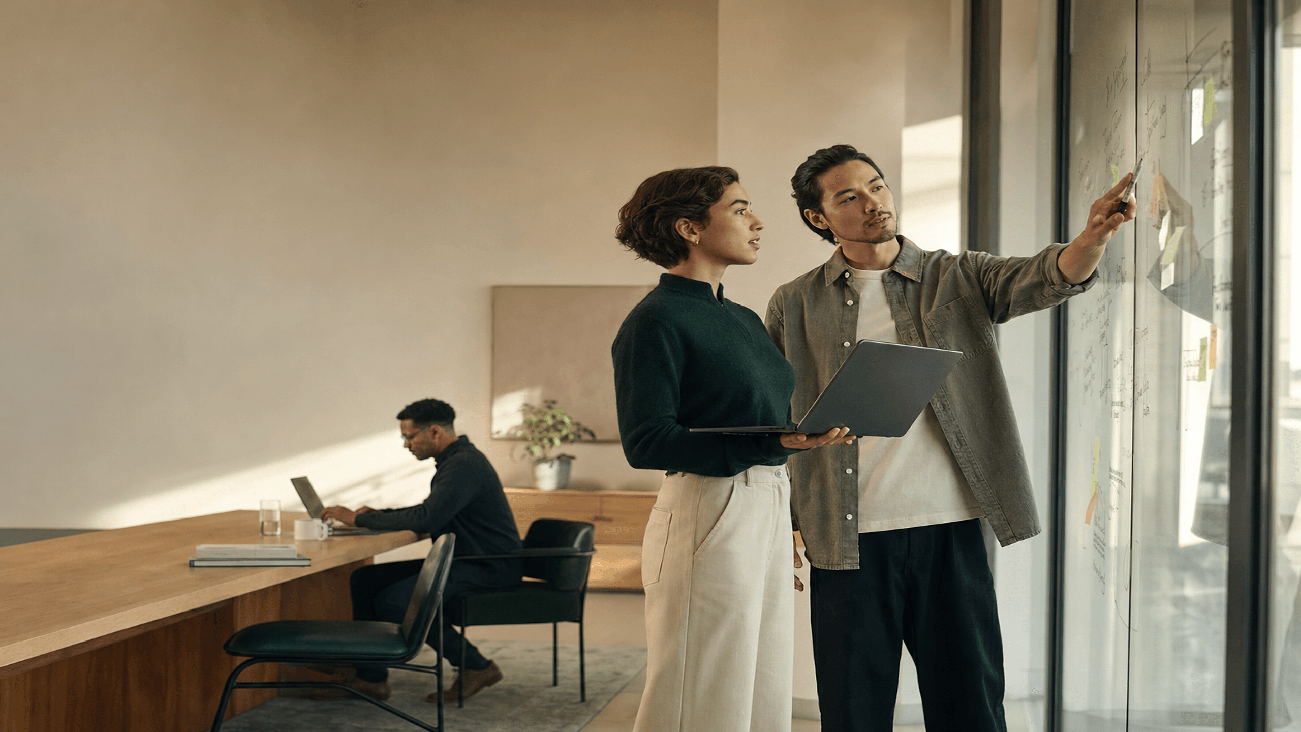 An operations team at work in a daylight office, reviewing a client onboarding board together